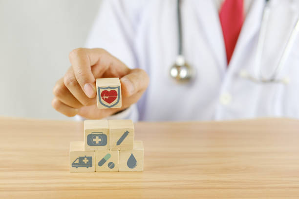 istock Doctor picking up a wooden cube with a heart shield icon 1463472940