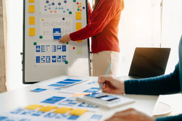 istock Close up view of UI developer team brainstorming on their project with laptop, smartphone and digital tablet. Creative digital development agency. 1463475014
