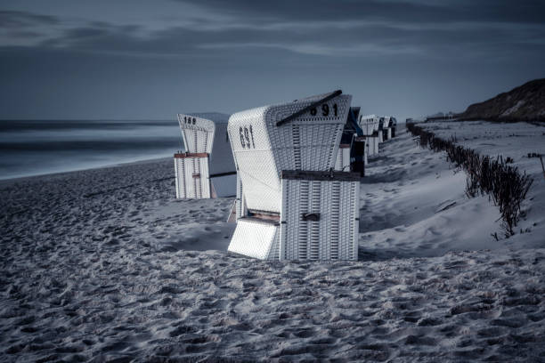 Hooded beach chairs on the beach in the evening stock photo