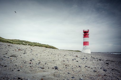 Landscape shot of cape recife lighthouse with reflection in the water on a clear blue sky day in summer