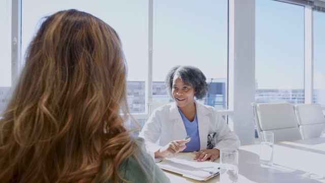 Female patient listens as doctor discusses medical test results