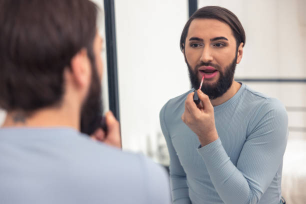 istock Attractive young man coloring his lips indoors 1463483551