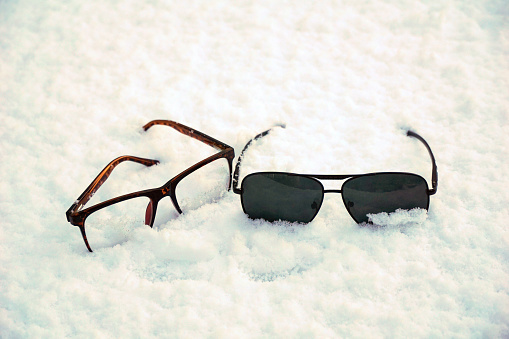trendy glasses lie on the snow. winter theme concept.