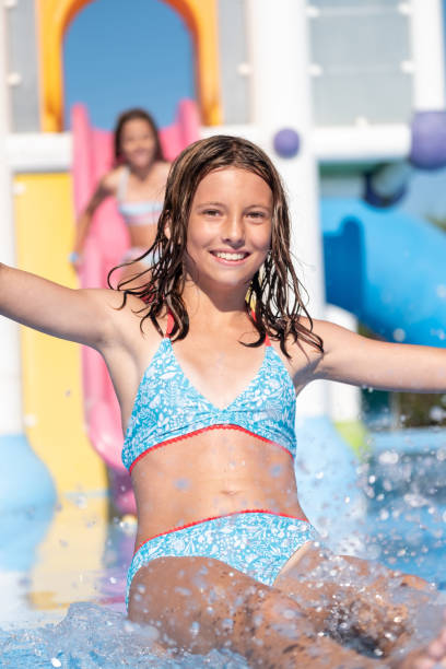 istock Cheerful girl having fun sliding in water park 1463487199