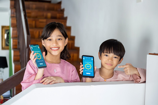 Kids showing smartphone to camera as they received 'duit raya' money gift via smartphone.