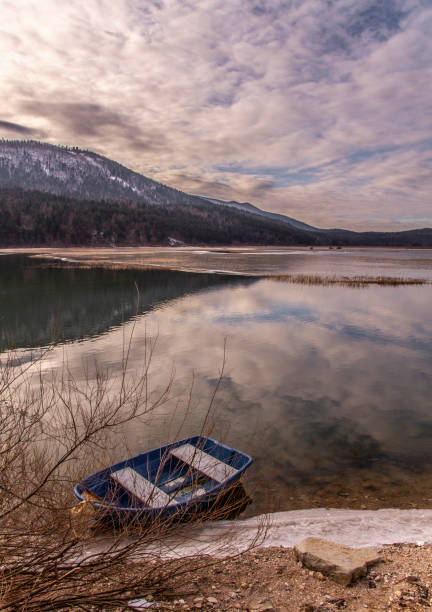 The blue boat A boat on the partially frozen Cerknica Lake, Slovenia. cerknica lake stock pictures, royalty-free photos & images