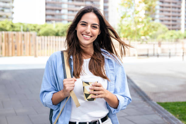 Young beautiful girl smiling and drinking take away coffee at the city. Close up portrait of a smiling young student. Close up portrait of a smiling young student. High quality photo spanish breakfast stock pictures, royalty-free photos & images