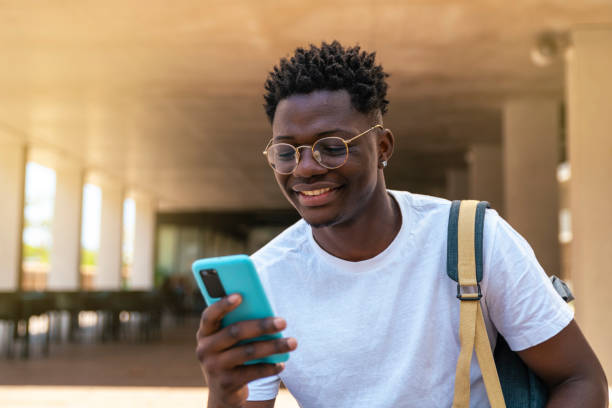 istock happy young student sitting and using his mobile phone in the university - Education concept 1463491680