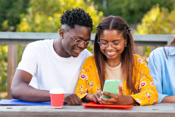 junges liebespaar, das zusammen telefoniert, kaffee trinkt und lernt - bildungskonzept - pair couple cheerful laughing stock-fotos und bilder