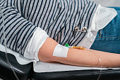 Unrecognizable female patient receiving IV drip, while lying on the examination table