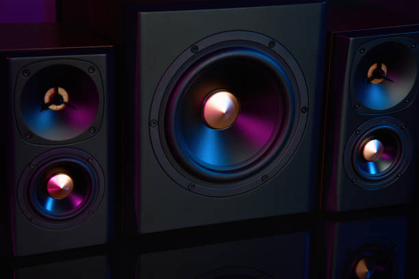 istock Two sound speakers and subwoofer on dark background with neon lights 1463492146