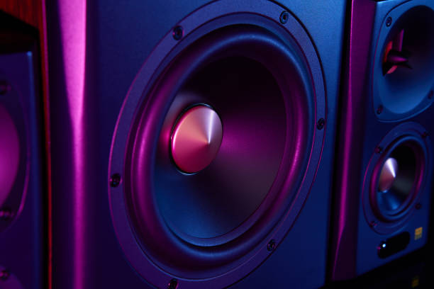 istock Two sound speakers and subwoofer on dark background with neon lights 1463492148