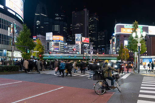 Night motion blur of train traffic transportation, Japanese people walk cross zebra crossing in Kabukicho Shinjuku Tokyo Japan, office building cityscape. Asia transport, Asian city life concept