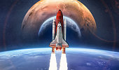 Space shuttle flight in deep space from Earth. Earth, Moon and Mars planet in space. Concept of spaceship mission to other worlds. Rocket launch in space. Elements of this image furnished by NASA