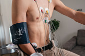 Male patient with electrodes on his chest, ready for a stress test on an exercise bicycle