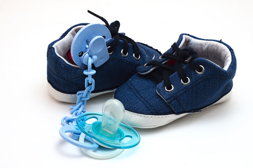 zapato de ropa y chupete de un bebé recién nacido photo