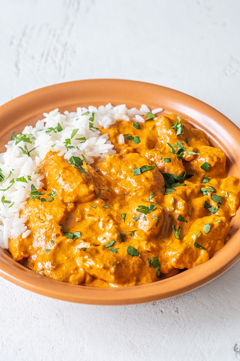 Bowl of Chicken tikka masala garnished with white rice