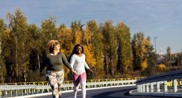 istock Two young plus size women jogging together. 1463500001