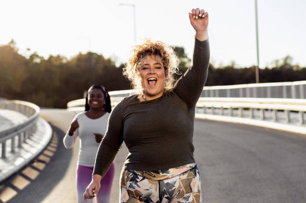 istock Two young plus size women jogging together. 1463500018