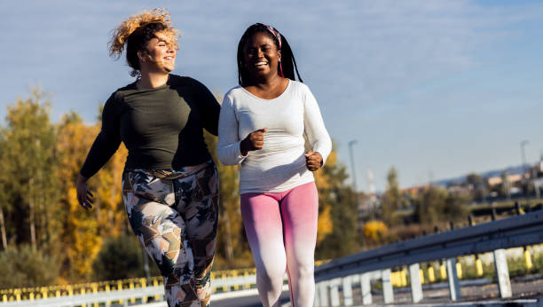 istock Two young plus size women jogging together. 1463500029