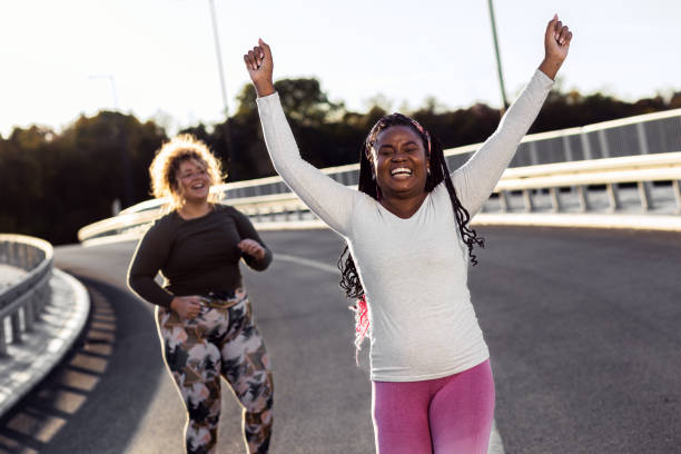 istock Two young plus size women jogging together. 1463500134