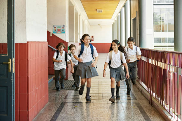 istock Competitive children racing in school hallway 1463500420