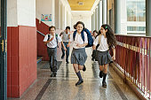 Smiling classmates racing in school hallway