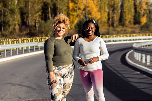 Portrait of two young plus size women preparing for run.