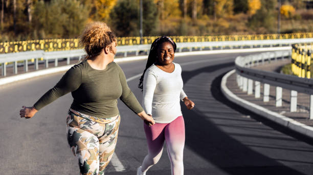 istock Two young plus size women jogging together. 1463500538