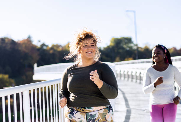 istock Two young plus size women jogging together. 1463500604