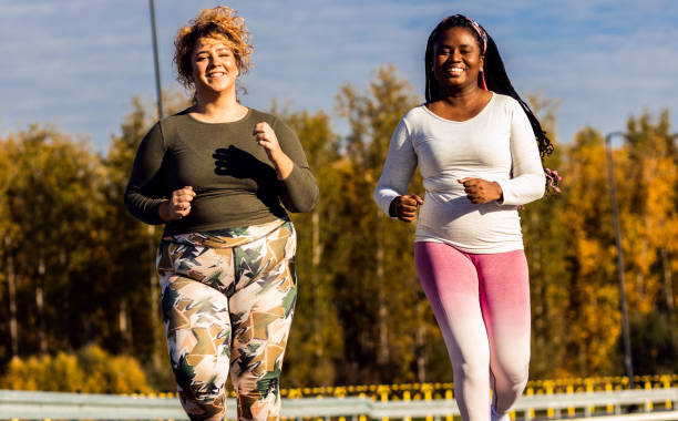 istock Two young plus size women jogging together. 1463500649