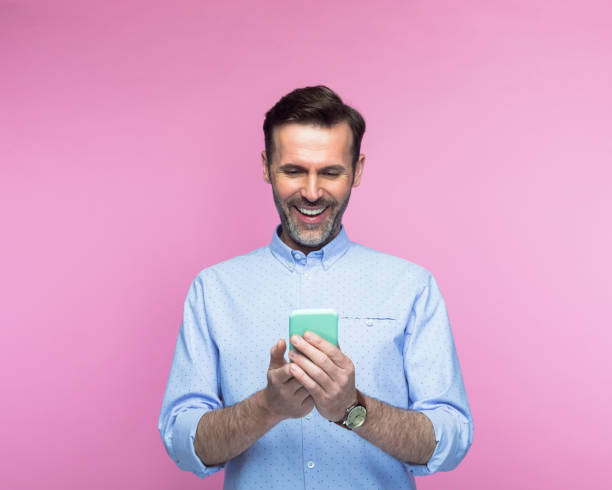 istock Happy mid adult man using smart phone 1463500689