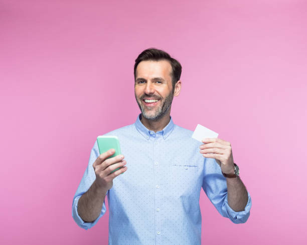istock Man with mobile phone showing credit card 1463500912