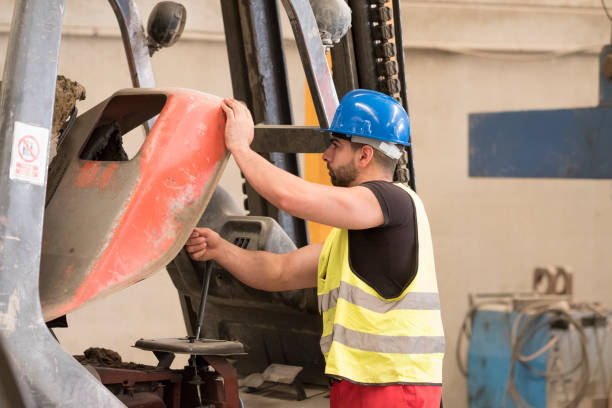 istock Young worker mechanic looking forklift, revise and repair engine 1463501688