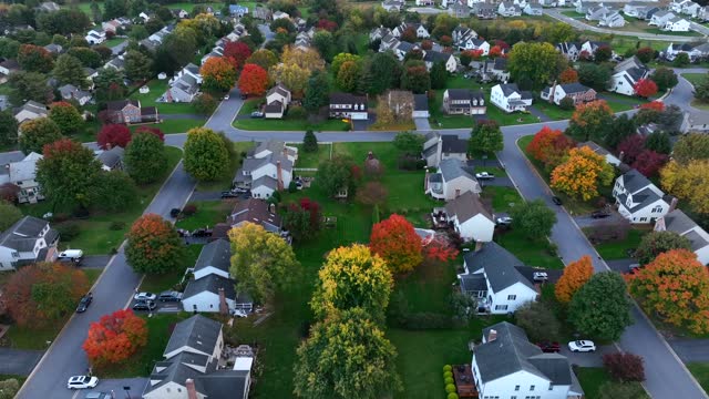 Residential street in autumn. Colorful fall foliage with American suburbia. Houses and homes along quiet street.