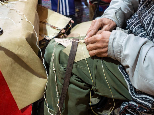 craftsman working slippers in a workshop of marrakech - craft market morocco shoe imagens e fotografias de stock