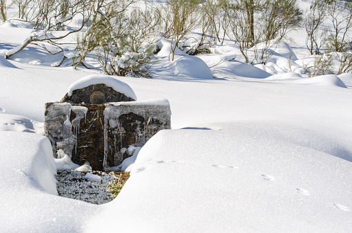 Snow-covered rural fountain