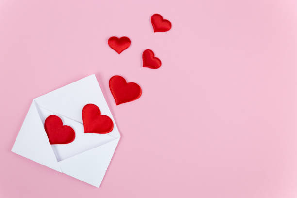 istock Red hearts falling out of a white envelope on a pink background. Valentine's Day 1463518439