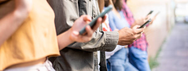 istock Horizontal banner with bored friends group using smartphone sitting at university backyard - Young people addicted by mobile smart phone - Technology sad life concept with always connected students 1463523099