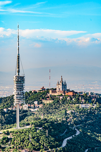 Aerial view of Torre de Collserola and in the background the Temple of the Sacred Heart of Jesus of Barcelona. Cityscape from helicopter. top view, On the Tibidado mountain