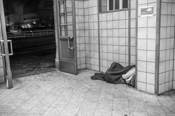 Sydney, Australia - June 08, 205: Pitt street, Sydney, despair homeless senior male begging in city street, side view, full frame horizontal composition, black and white