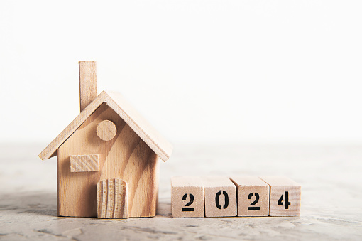 Happy New Year minimal concept with house model on table background.