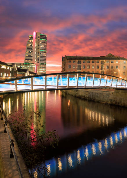 Leeds city centre at sunset. This bridge opened in February 2023 and commemorates David Oluwale, who tragically drowned in the River Aire in 1969. The image also shows Bridgewater Place, one of the city's tallest buildings.