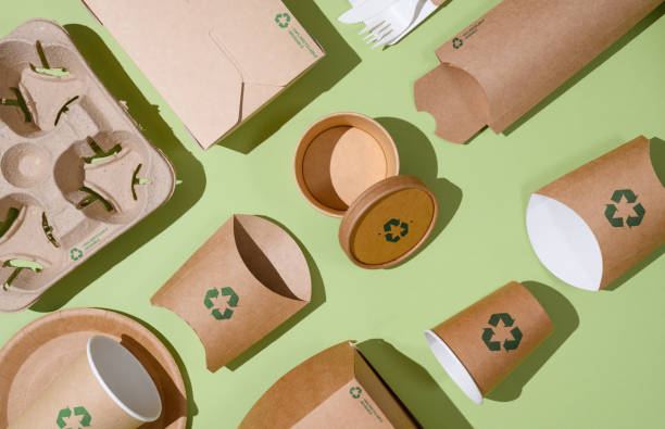 istock Disposable eco-friendly packaging with a recycling sign on a green background. Reusable raw materials. 1463536169