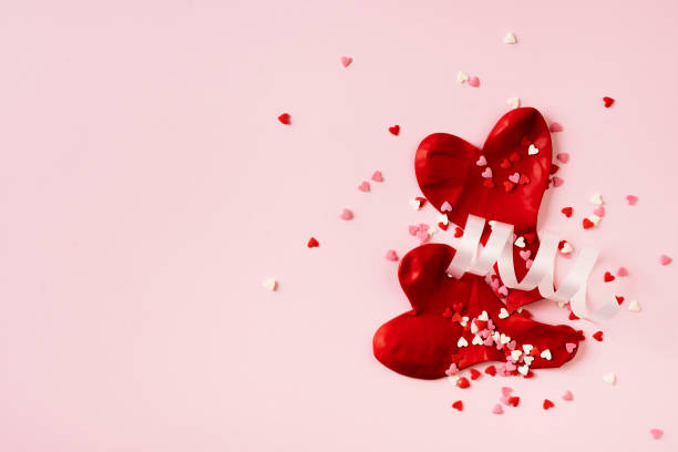 istock Red balloons and confetti on pink background 1463537281