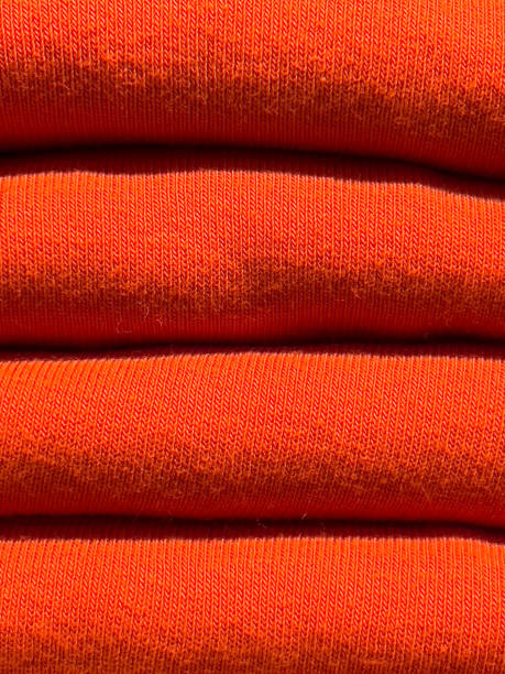 istock textured background of orange dyed wool knitted sweaters folded in a pile. 1463537845