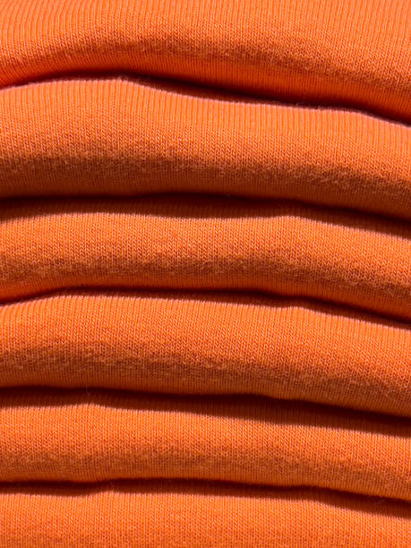 istock textured background of orange dyed wool knitted sweaters folded in a pile. 1463537850