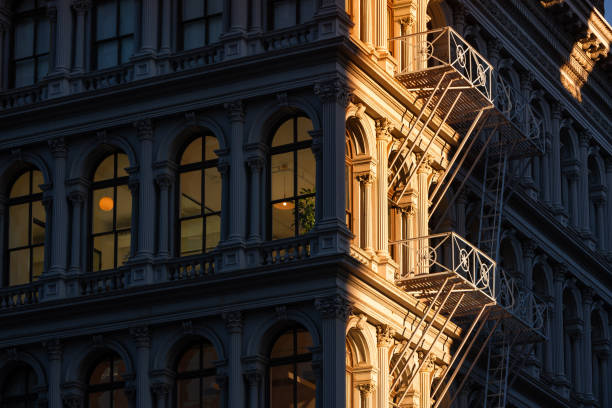 Last sun rays on Soho loft buildings with facade ornamentation and fire escape. Lower Manhattan, New York City