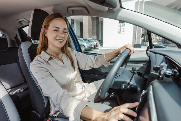 istock Young woman driving car and using car features 1463544204