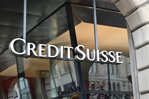 Zurich, Switzerland, 12 20 2022, Credit Suisse bank logo created with big white letters is placed on modern building. Branch office of the bank accommodated in an renewed house with big glass windows.